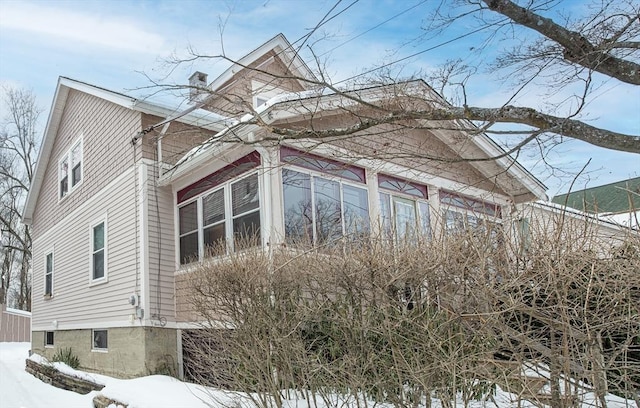 snow covered property featuring a chimney