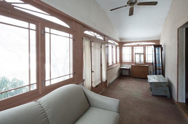 sunroom featuring ceiling fan, a baseboard heating unit, and vaulted ceiling