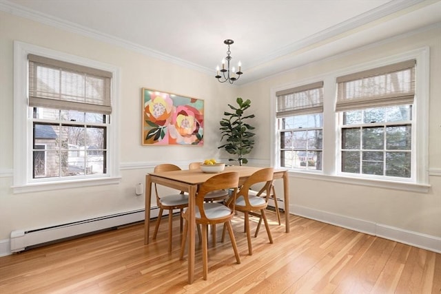 dining room with baseboard heating, a healthy amount of sunlight, crown molding, and light wood-style floors