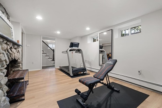 exercise area featuring recessed lighting, a fireplace, light wood-type flooring, and plenty of natural light