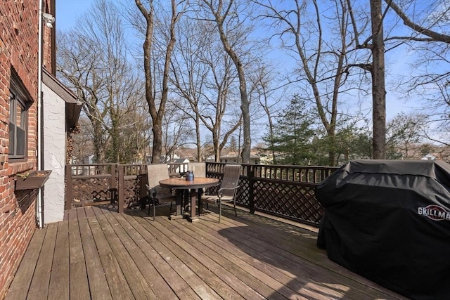 deck featuring outdoor dining space and grilling area