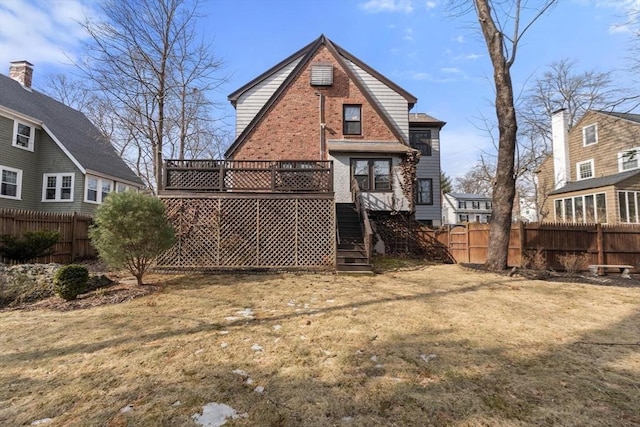 back of property featuring a deck, a yard, and fence