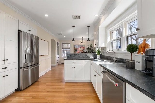 kitchen featuring white cabinetry, ornamental molding, visible vents, and stainless steel appliances