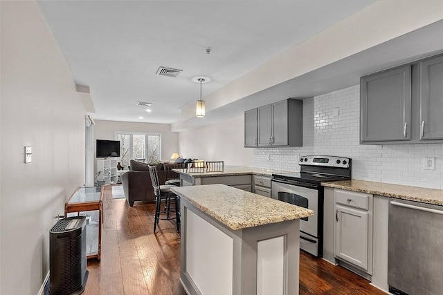 kitchen featuring dark wood-type flooring, appliances with stainless steel finishes, tasteful backsplash, and gray cabinetry