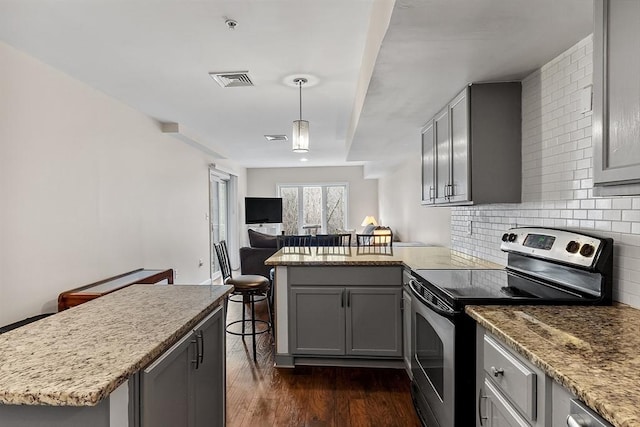 kitchen featuring stainless steel range with electric stovetop, backsplash, gray cabinetry, and hanging light fixtures