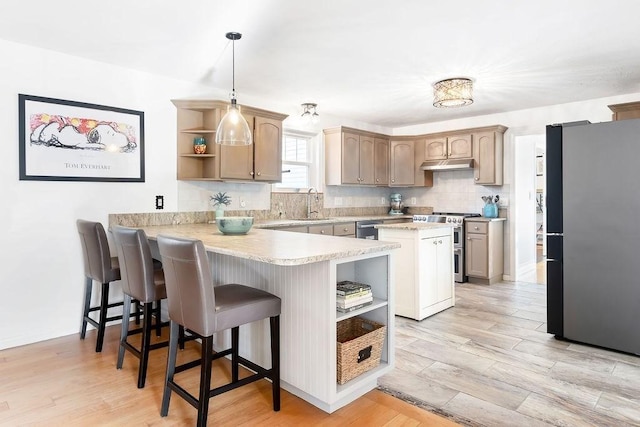 kitchen with open shelves, light countertops, stainless steel appliances, a peninsula, and under cabinet range hood