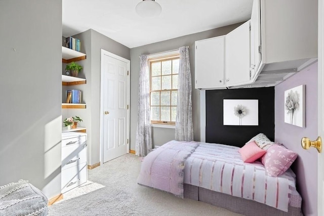 bedroom with baseboards and light carpet