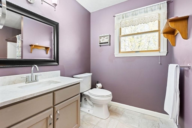 bathroom featuring vanity, toilet, a shower with shower curtain, marble finish floor, and baseboards