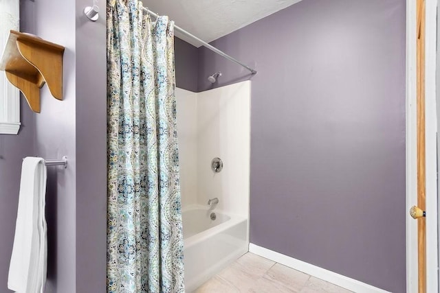 full bath featuring shower / bath combo with shower curtain, baseboards, and tile patterned flooring
