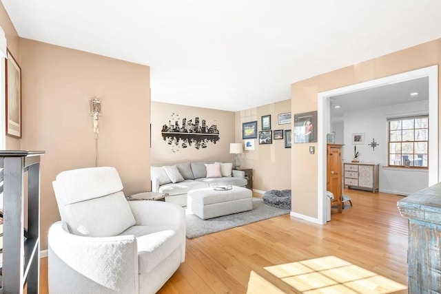 living area featuring baseboards and light wood-style flooring