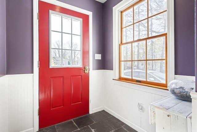 doorway with wainscoting and a healthy amount of sunlight