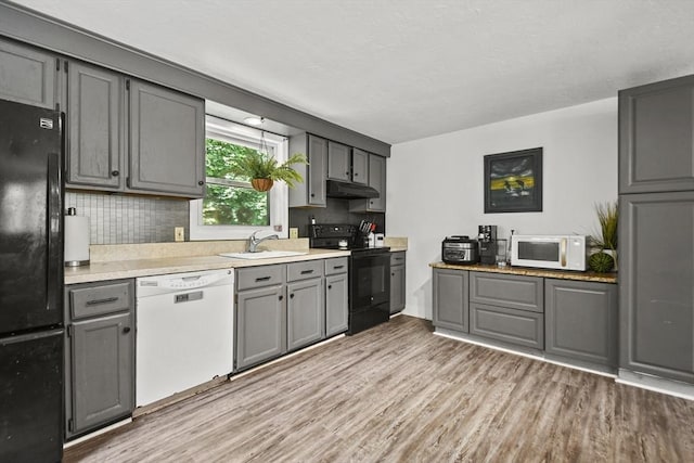 24 Lynn Ln, Southbridge, MA 01550 - kitchen featuring black appliances, gray cabinets, under cabinet range hood, light wood finished floors, and backsplash