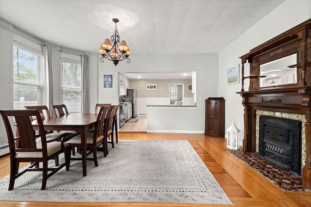 12 Summit Ave Unit 1, Salem, MA 01970 - dining area featuring light wood-type flooring, a chandelier, and a fireplace with flush hearth