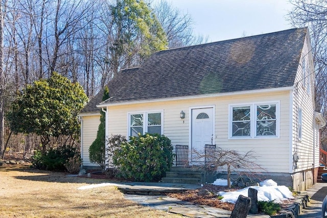 cape cod-style house featuring roof with shingles