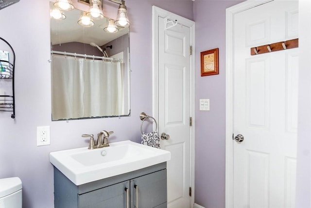 bathroom with curtained shower, toilet, and vanity