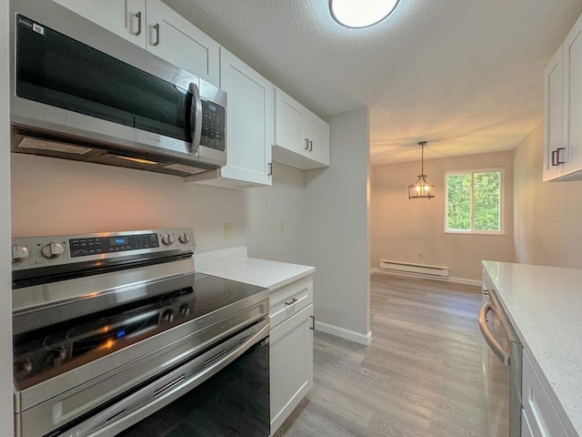 kitchen with light countertops, white cabinets, baseboard heating, and appliances with stainless steel finishes