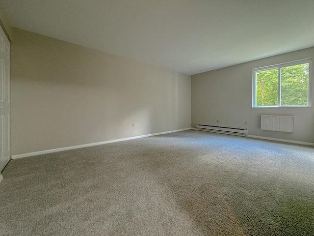 spare room featuring a baseboard radiator, carpet flooring, and baseboards