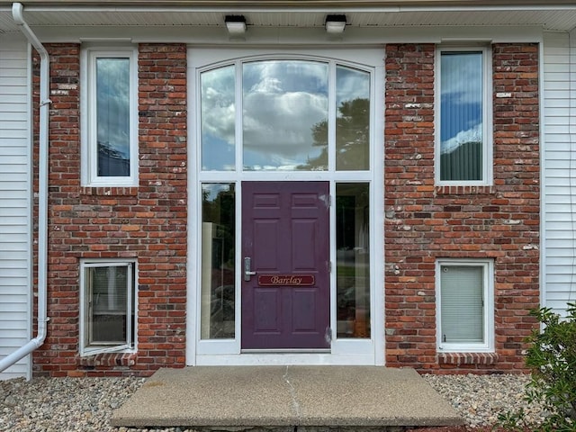 property entrance featuring brick siding