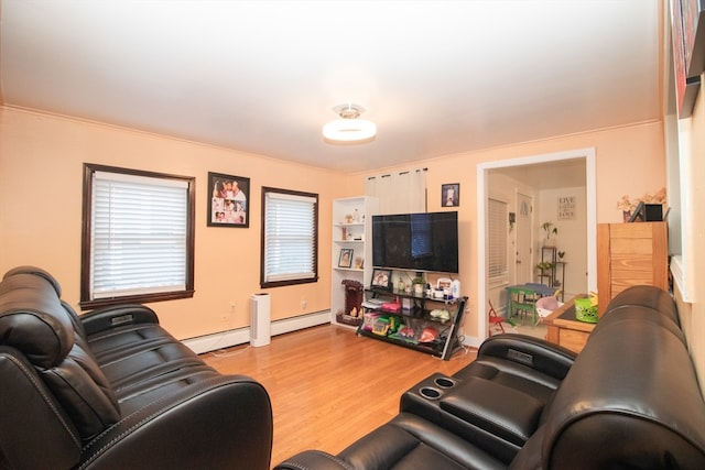 living room with crown molding, a baseboard heating unit, and light hardwood / wood-style floors