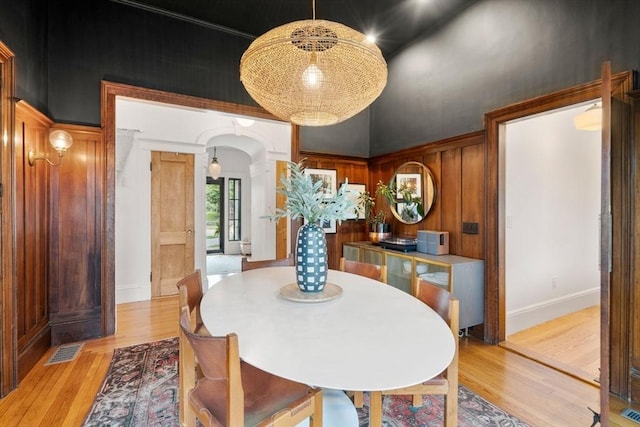 332 Eliot St, Milton, MA 02186 - dining space with arched walkways, light wood finished floors, a high ceiling, and decorative columns