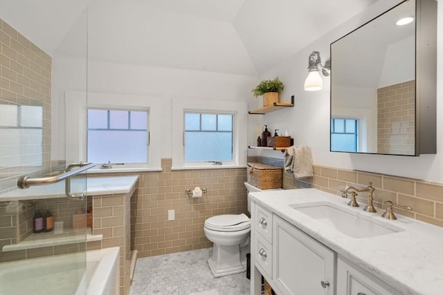 332 Eliot St, Milton, MA 02186 - bathroom with vanity, tile walls, a shower with door, tile patterned floors, and vaulted ceiling