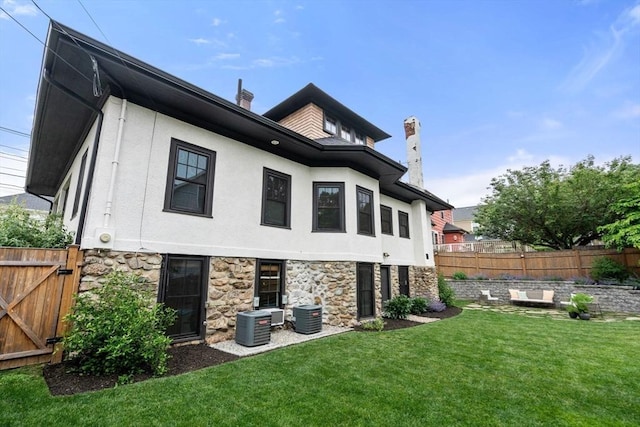 332 Eliot St, Milton, MA 02186 - rear view of house with stone siding, stucco siding, a chimney, and a gate