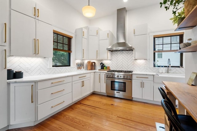 332 Eliot St, Milton, MA 02186 - kitchen with stainless steel range, wall chimney range hood, light countertops, and white cabinets