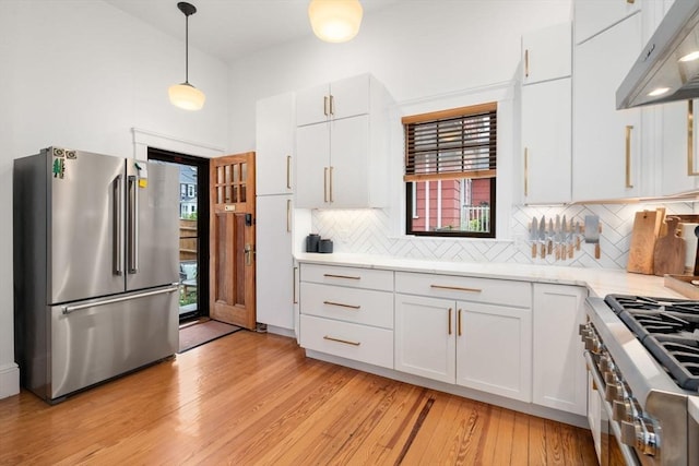 332 Eliot St, Milton, MA 02186 - kitchen featuring high quality appliances, wall chimney exhaust hood, light wood-style flooring, decorative backsplash, and white cabinetry