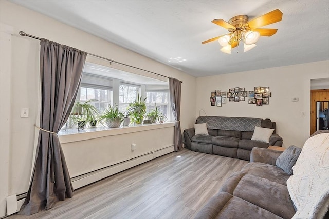 living room with baseboard heating, ceiling fan, and wood finished floors