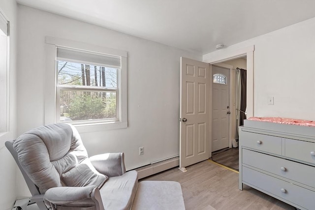 living area featuring baseboard heating and light wood-style flooring
