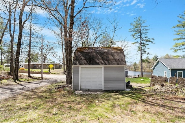 view of outdoor structure with an outbuilding, a water view, and dirt driveway