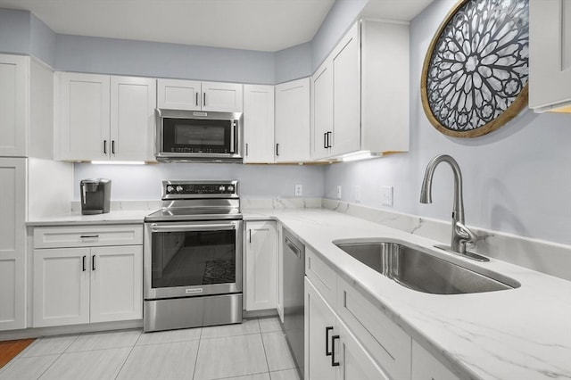 179 Hillside Village Dr Unit 179, West Boylston, MA 01583 - kitchen featuring stainless steel appliances, a sink, white cabinets, light stone countertops, and light tile patterned flooring