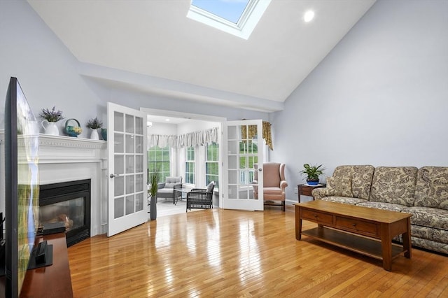 179 Hillside Village Dr Unit 179, West Boylston, MA 01583 - living area featuring wood-type flooring, a skylight, a glass covered fireplace, high vaulted ceiling, and recessed lighting