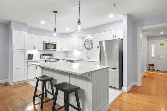179 Hillside Village Dr Unit 179, West Boylston, MA 01583 - kitchen featuring appliances with stainless steel finishes, a sink, baseboards, a center island, and light wood finished floors
