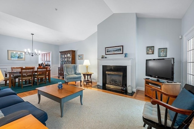 17 Cortland Grove Dr Unit 17, Shrewsbury, MA 01545 - living area with a chandelier, wood finished floors, a glass covered fireplace, and a wainscoted wall