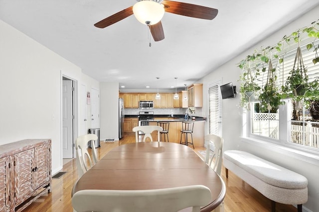 dining room featuring ceiling fan and light wood finished floors