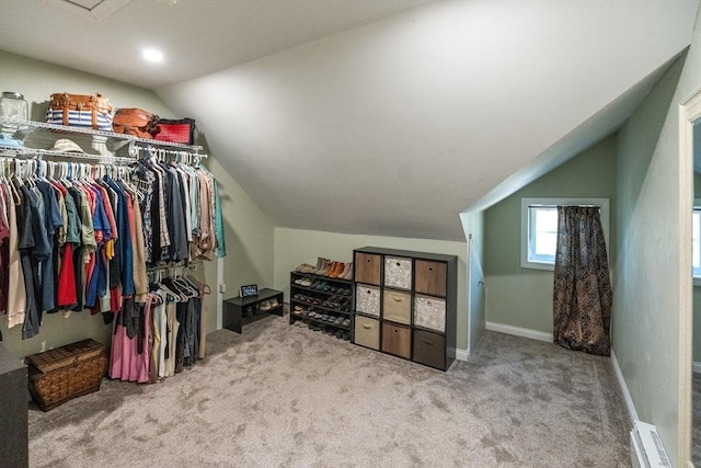 spacious closet featuring carpet, vaulted ceiling, and a baseboard radiator