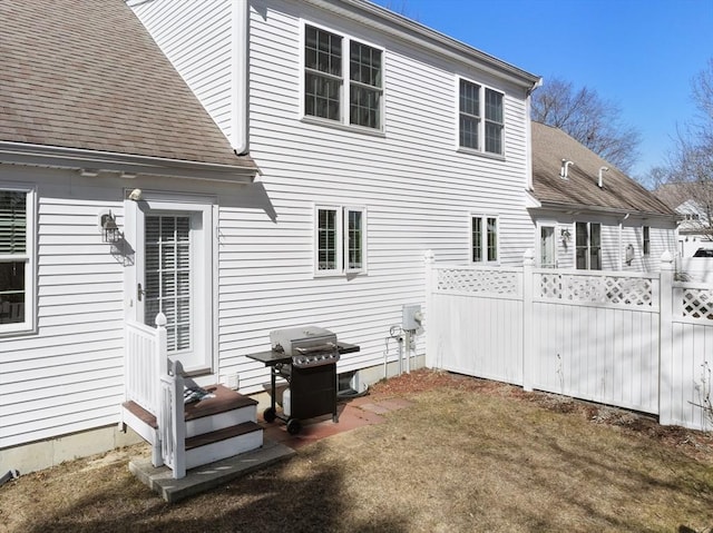 back of property featuring roof with shingles and fence