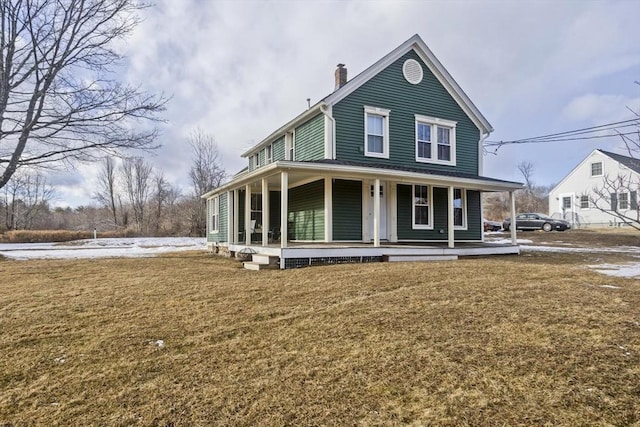 country-style home featuring covered porch and a front yard