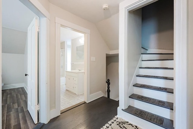 stairs featuring vaulted ceiling, wood finished floors, and baseboards