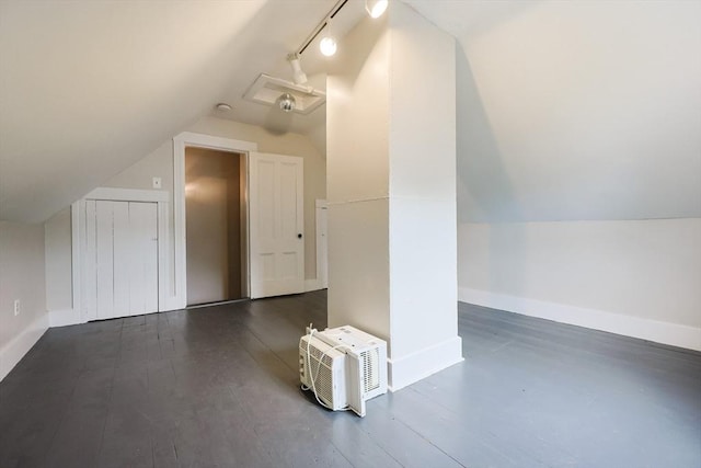 additional living space with vaulted ceiling, wood finished floors, and baseboards