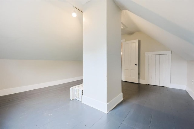 bonus room with vaulted ceiling, wood finished floors, and baseboards