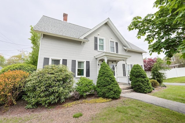 view of front of property with a chimney and a shingled roof