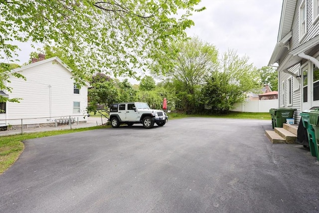 view of parking / parking lot featuring fence