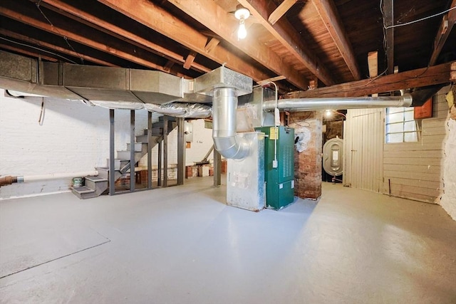 unfinished below grade area featuring stairway, oil tank, and heating unit