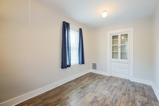empty room featuring baseboards and wood finished floors
