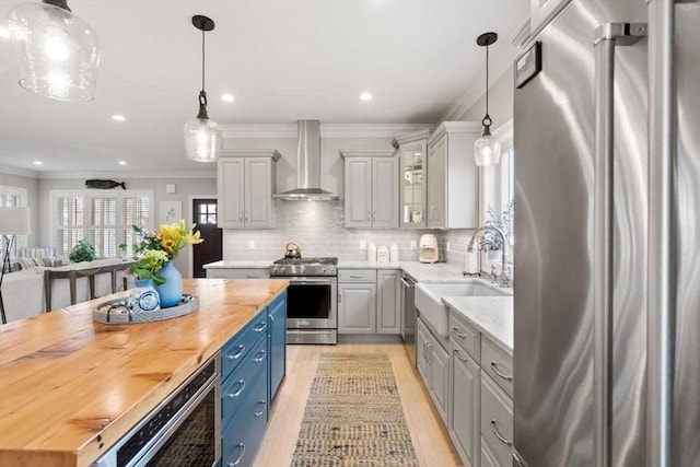 7 Bethpage Ln, Plymouth, MA 02360 - kitchen featuring wall chimney range hood, crown molding, a sink, stainless steel appliances, and light wood-style flooring