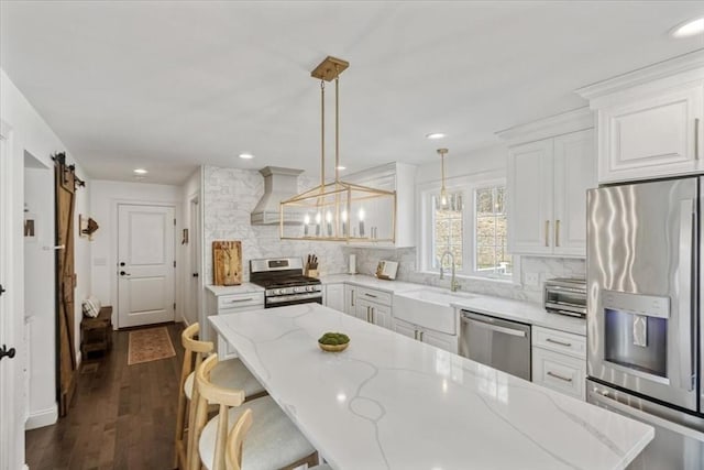 4 Barrows Brook Cir, Kingston, MA 02364 - kitchen featuring appliances with stainless steel finishes, a sink, premium range hood, backsplash, and a breakfast bar area