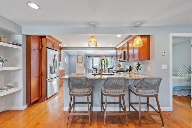 9 Crescent Ave, Lynnfield, MA 01940 - kitchen with appliances with stainless steel finishes, a peninsula, light wood finished floors, light stone countertops, and brown cabinetry