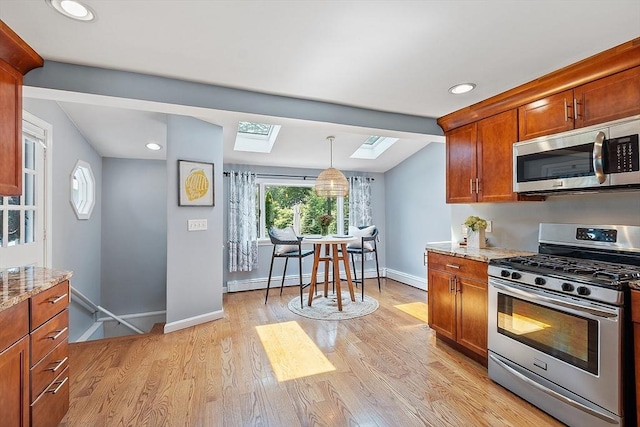 9 Crescent Ave, Lynnfield, MA 01940 - kitchen featuring stainless steel appliances, a skylight, light stone countertops, light wood-style flooring, and recessed lighting